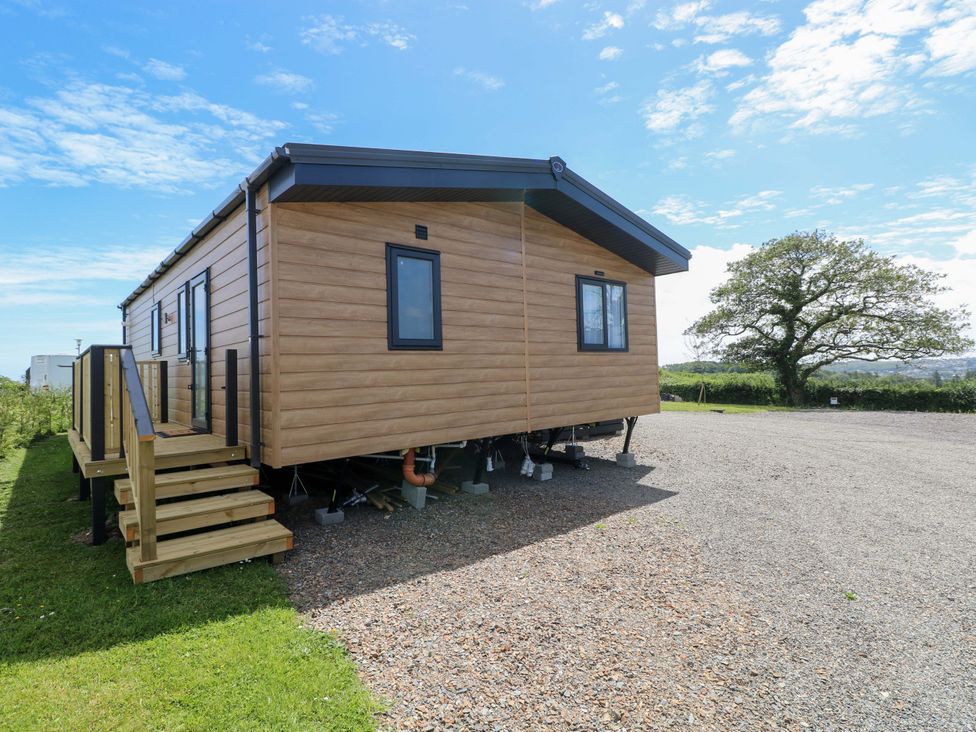 A mobile home with steps and grassy area at Sandpiper in Narberth