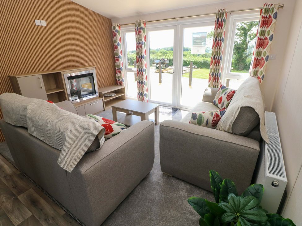 A living room with sofas and a television at Sandpiper in Narberth
