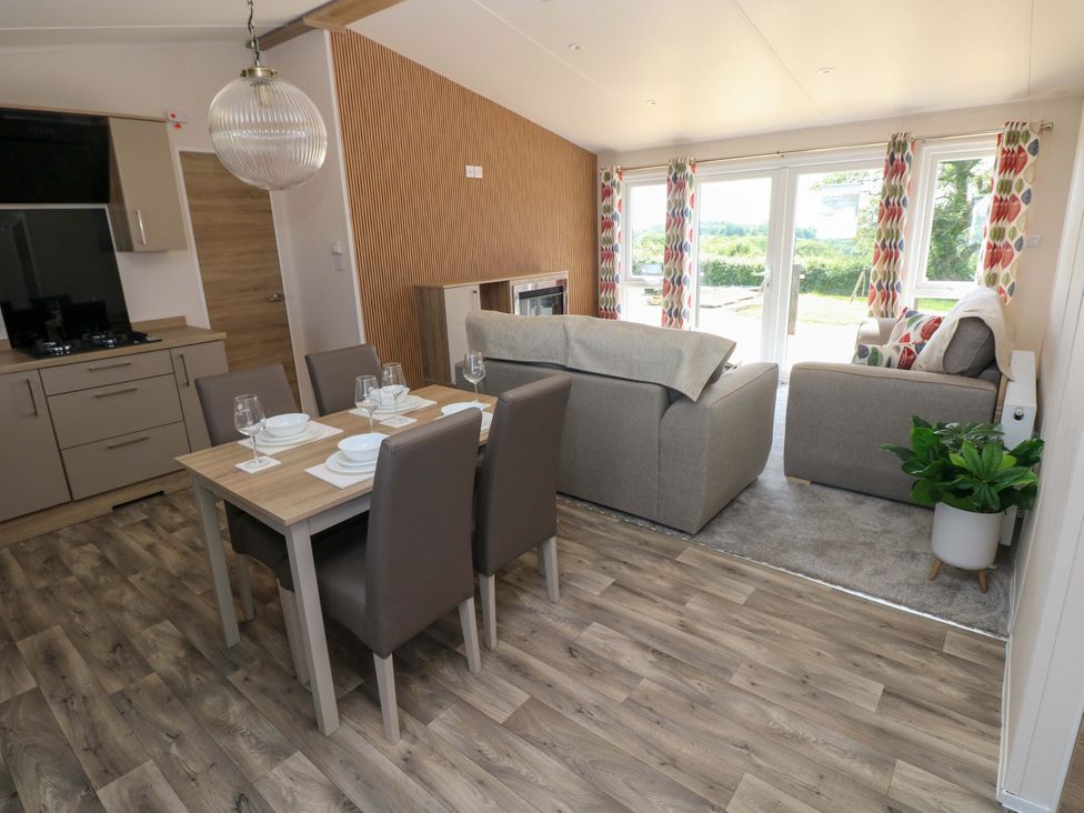 A living room with a dining table and chairs at Sandpiper in Narberth