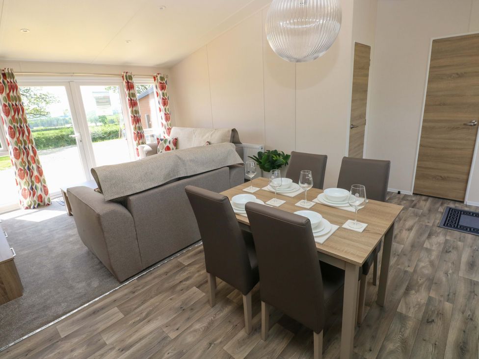 A living room with a sofa and dining table at Sandpiper in Narberth