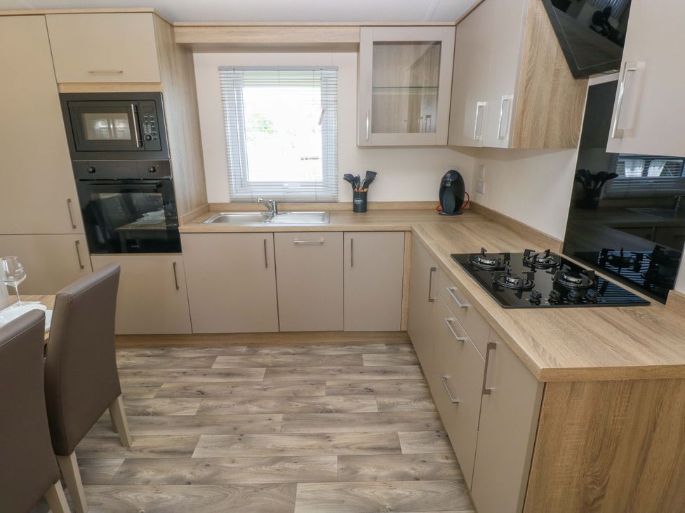 A kitchen with a sink and gas stove at Sandpiper in Narberth
