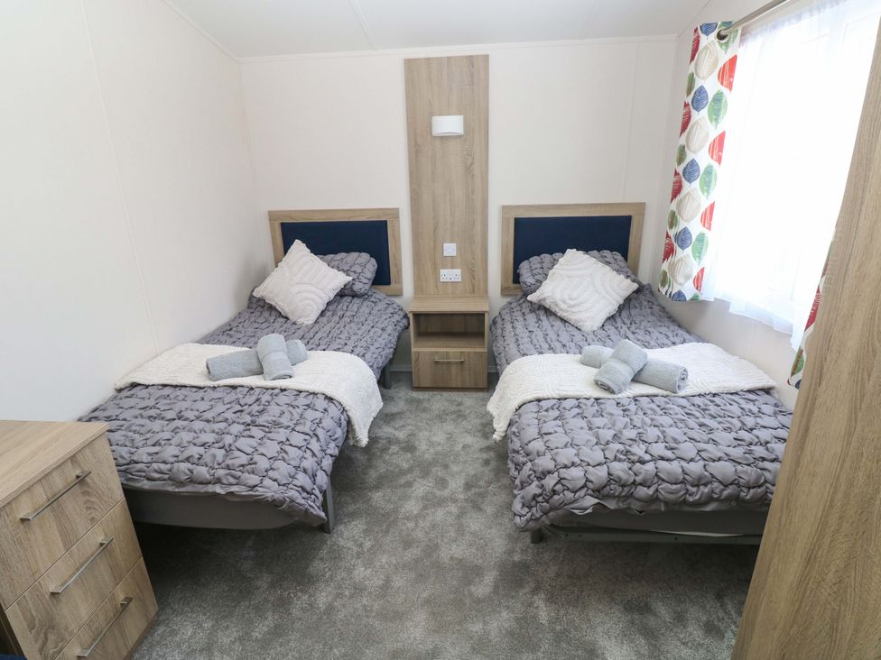 A bedroom with twin beds and a dresser at Sandpiper in Narberth