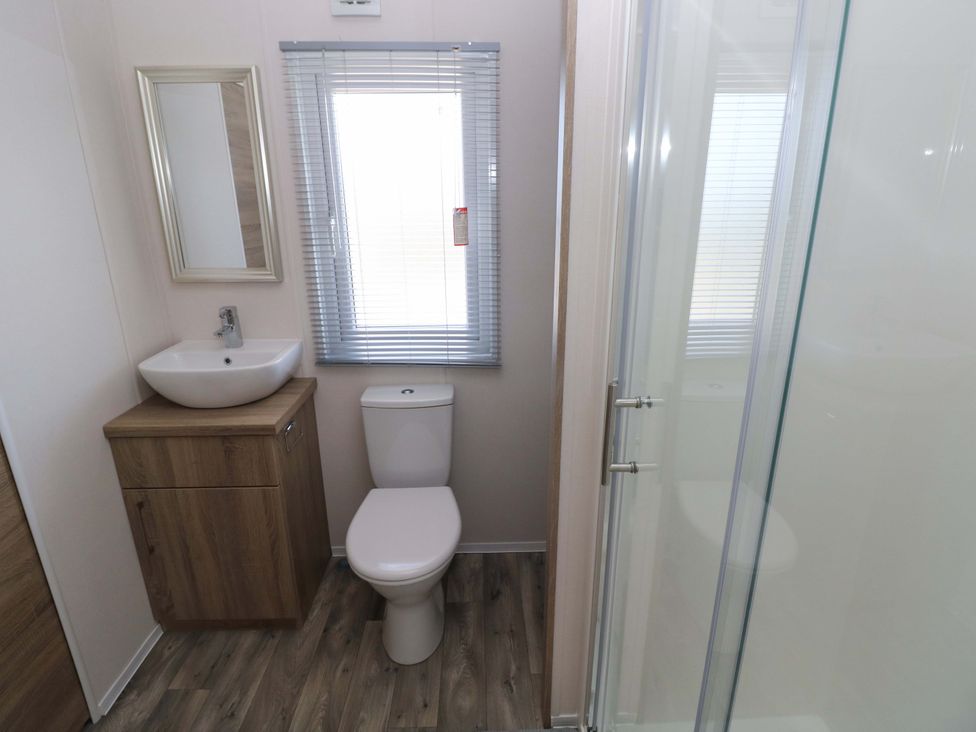 A bathroom with a sink, toilet and shower at Sandpiper in Narberth