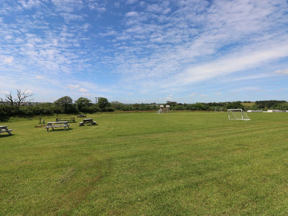An outdoor area with picnic tables and soccer goals at Sandpiper in Narberth