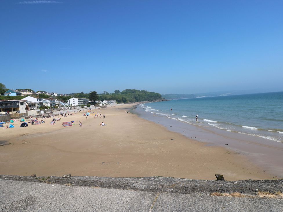 A beach with people and tents near houses at Sandpiper in Narberth