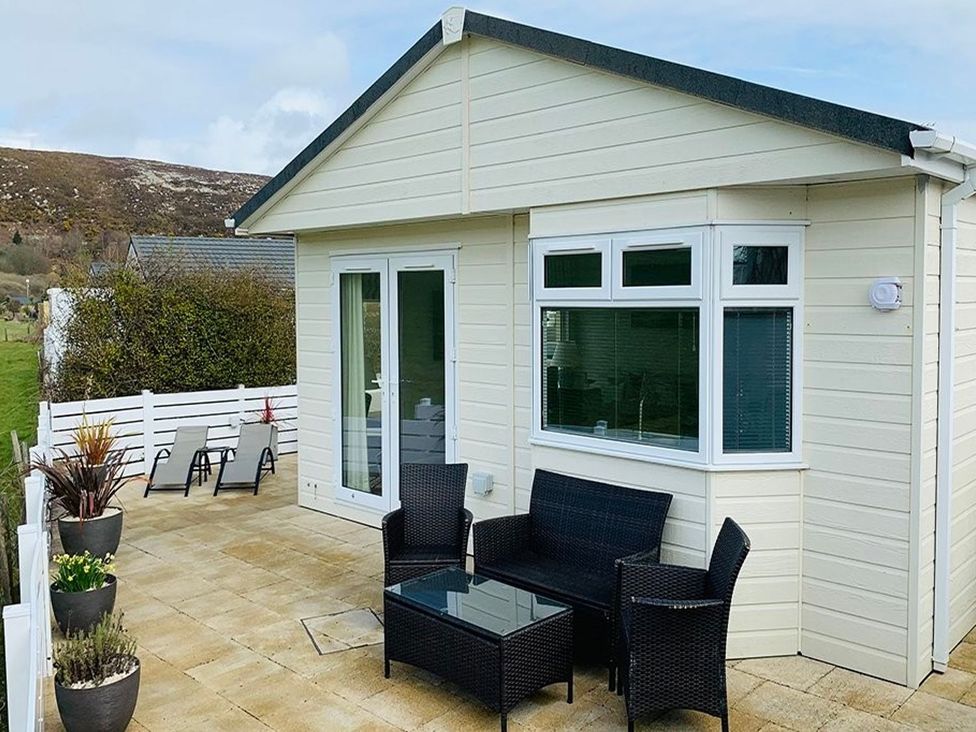 A house with a deck and chairs at O7 in Abersoch