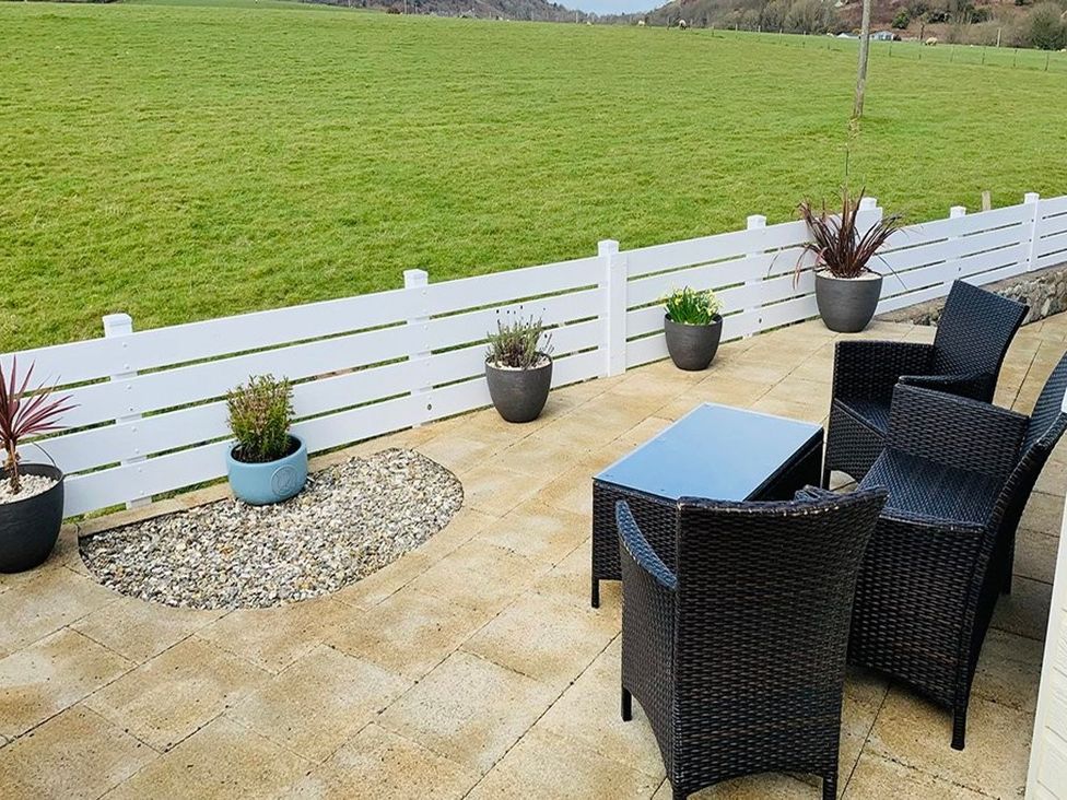 An outdoor patio area with chairs and a table at O7 in Abersoch