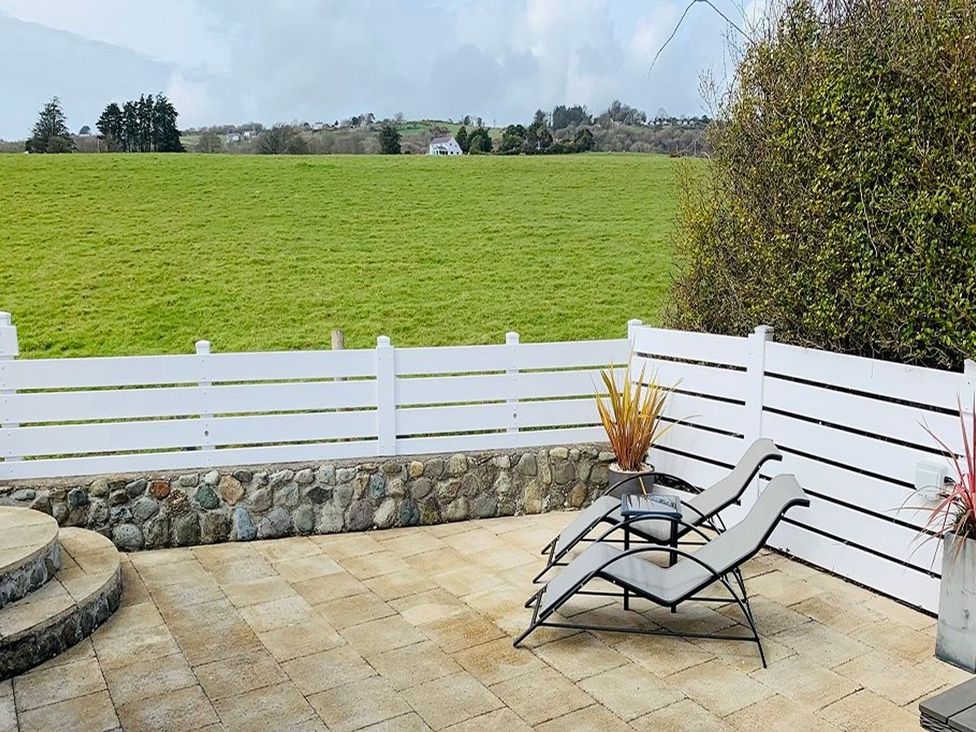 An outdoor area with loungers and a view of the lawn at O7 in Abersoch