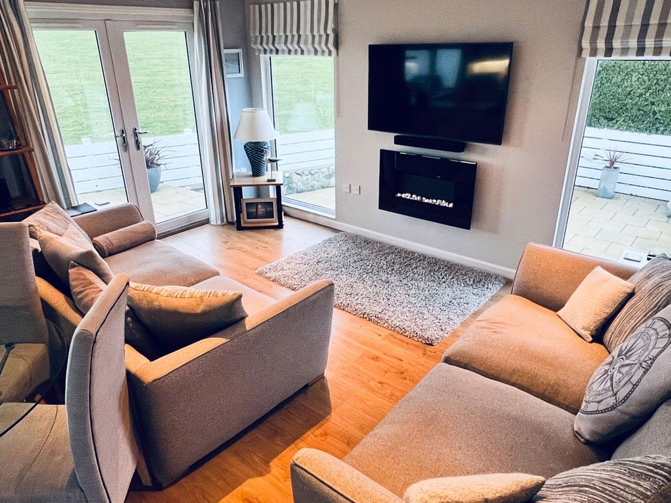 A living room with a television and fireplace at O7 in Abersoch