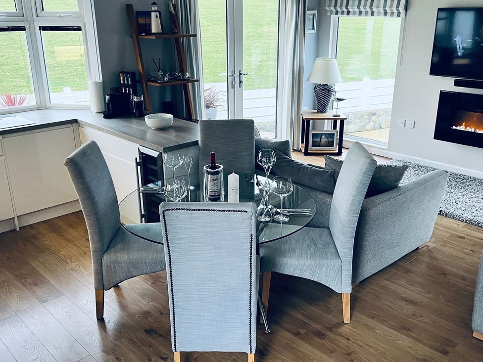 A dining room with a round table and chairs at O7 in Abersoch