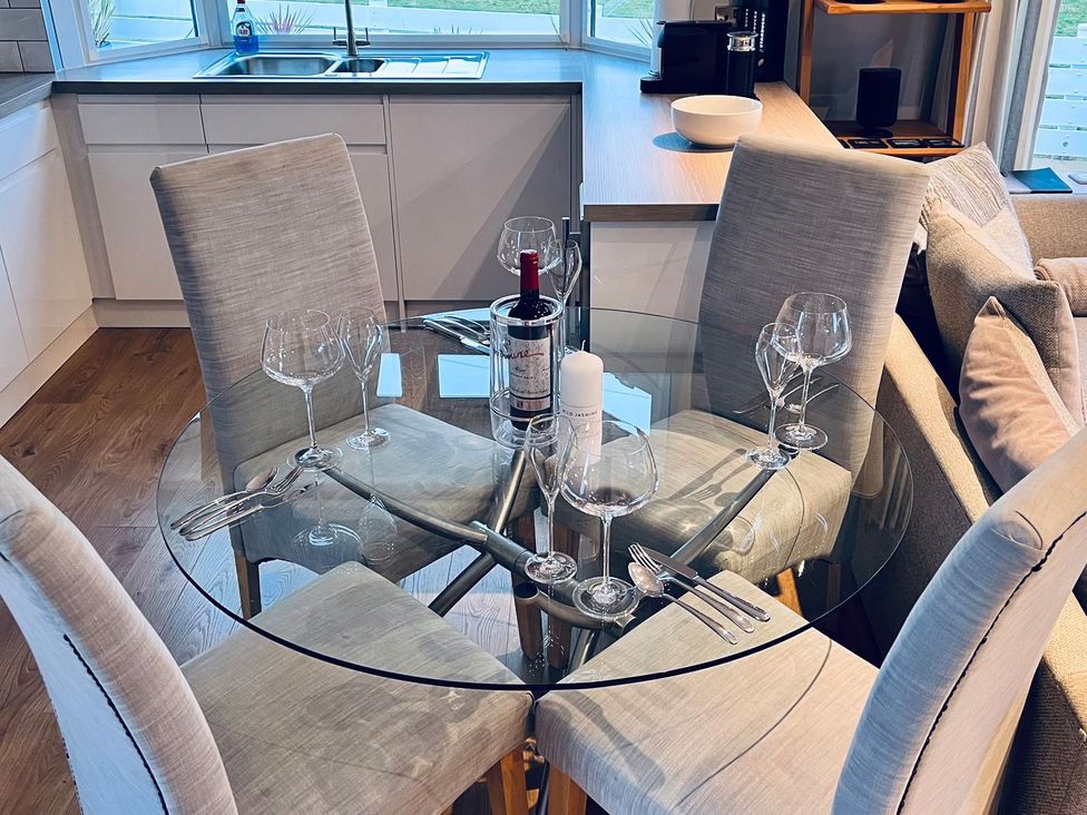A dining room with a glass table and chairs at O7 in Abersoch