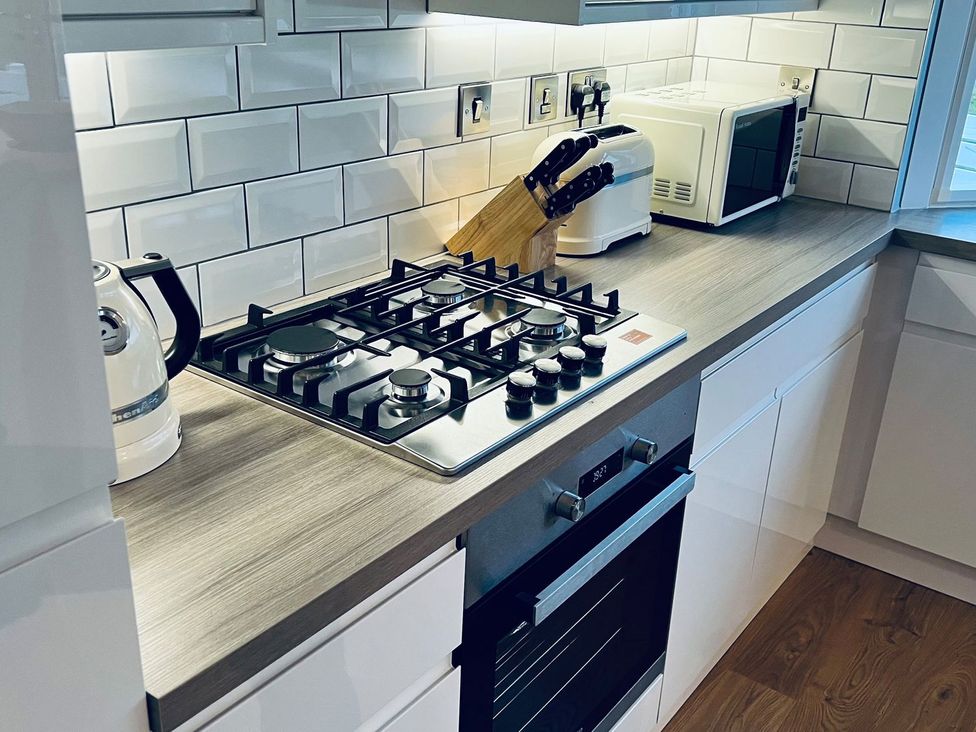 A kitchen with a gas stove and appliances at O7 in Abersoch