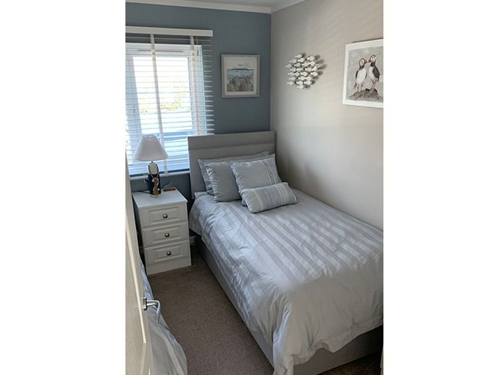 A bedroom with a bed and bedside table at O7 in Abersoch