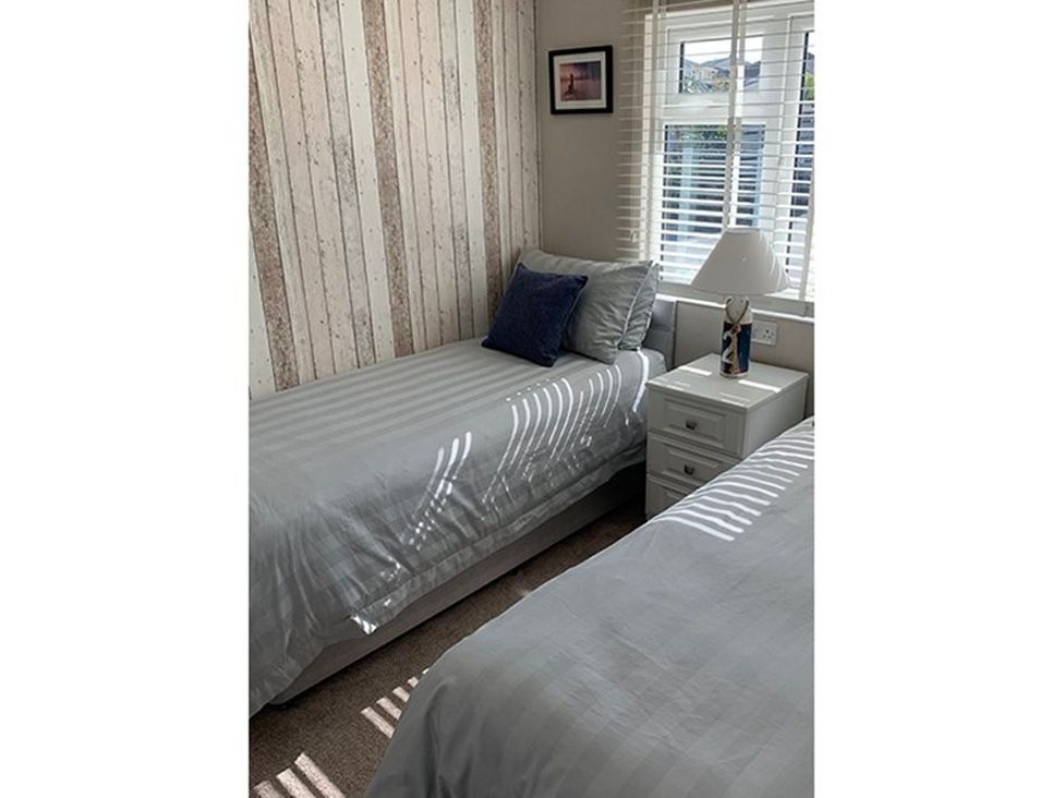 A bedroom with two beds and a nightstand at O7 in Abersoch