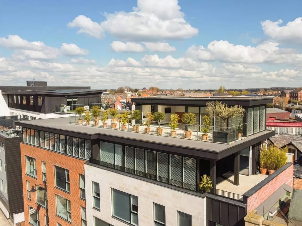 A roof terrace with planters and a glass railing at The Penthouse in Shrewsbury