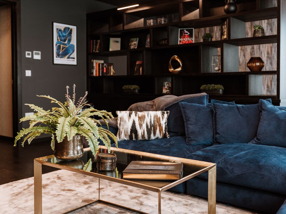 A living room with a sofa and bookshelves at The Penthouse in Shrewsbury