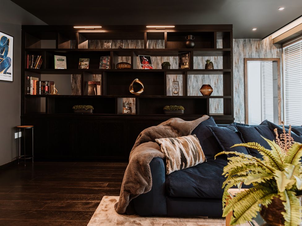 A living room with a sofa and bookshelves at The Penthouse in Shrewsbury