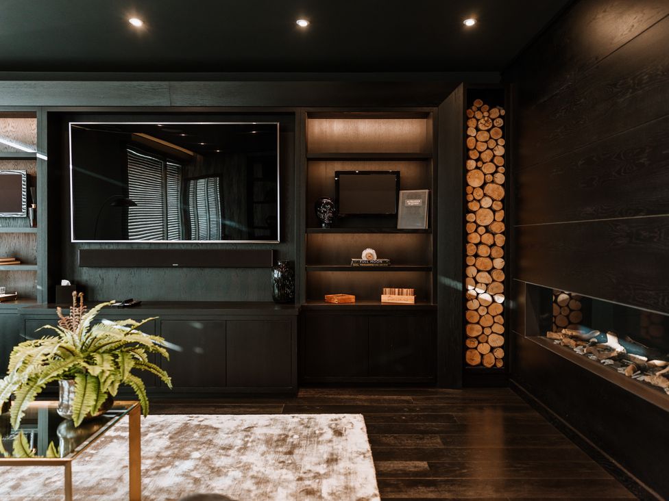 A living room with a television and shelving units at The Penthouse in Shrewsbury