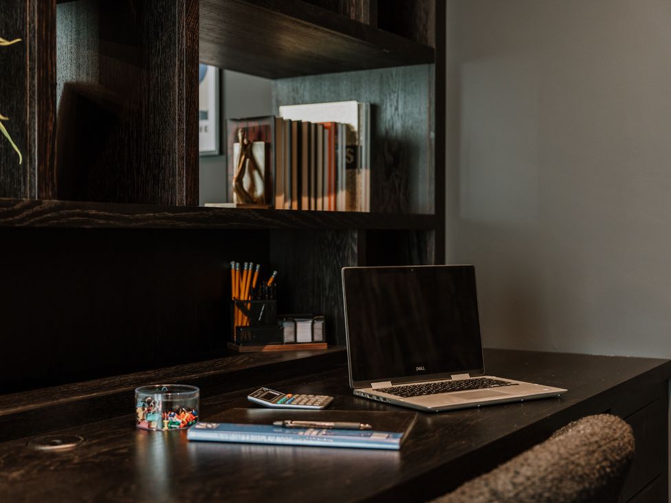 An office with a desk, laptop, books, and a calculator at The Penthouse in Shrewsbury