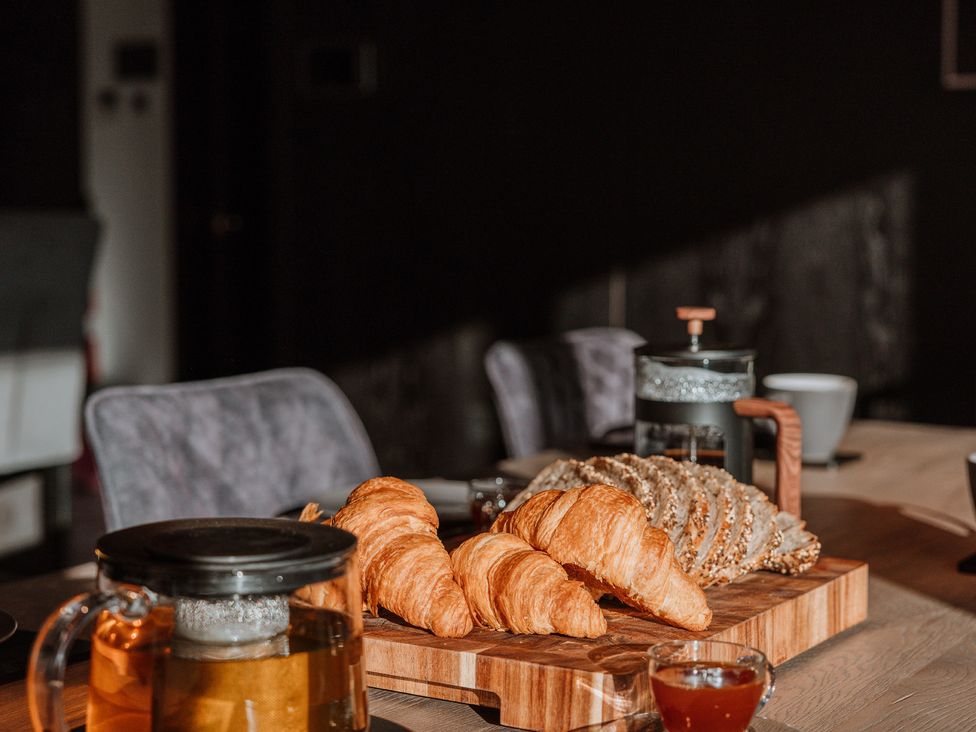 A dining table with croissants and tea at The Penthouse in Shrewsbury