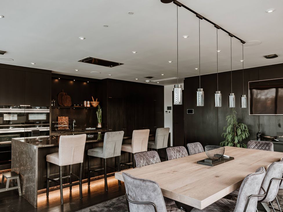 A kitchen with a wooden dining table and stools at The Penthouse in Shrewsbury