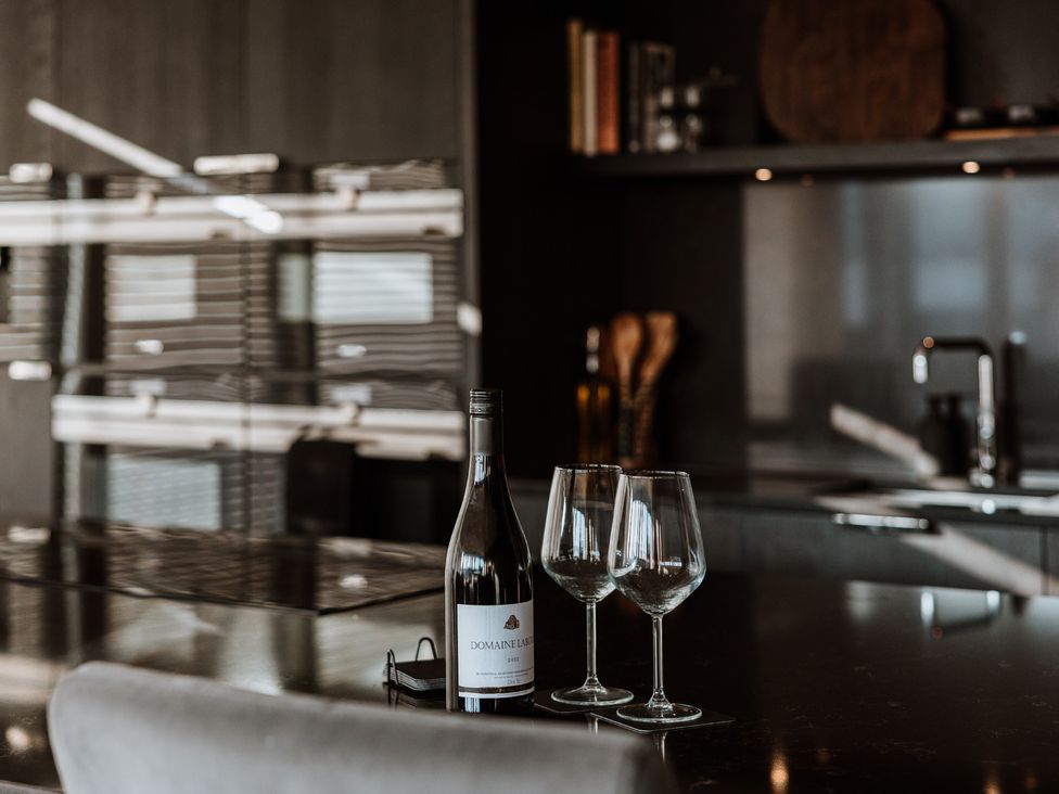 A kitchen with a wine bottle and glasses on the counter at The Penthouse in Shrewsbury