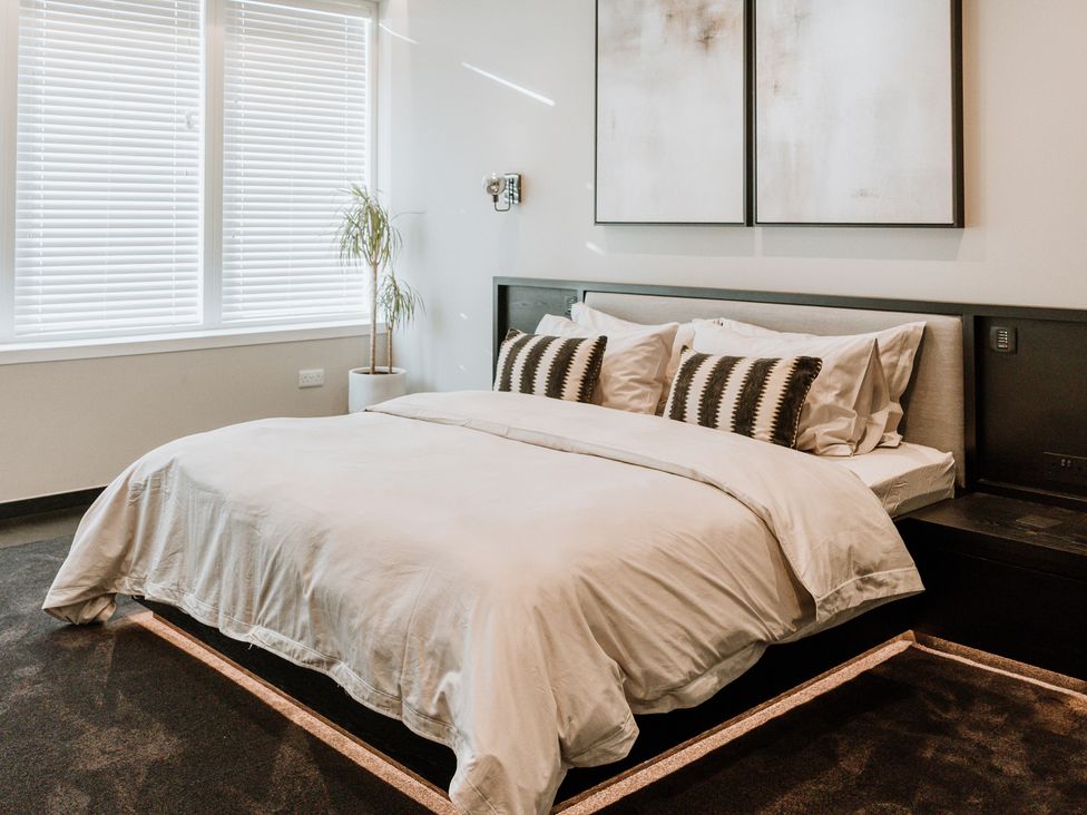 A bedroom with a bed and decorative wall art at The Penthouse in Shrewsbury