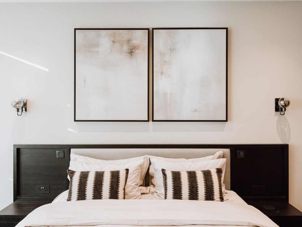 A bedroom featuring a bed with pillows and wall art at The Penthouse in Shrewsbury