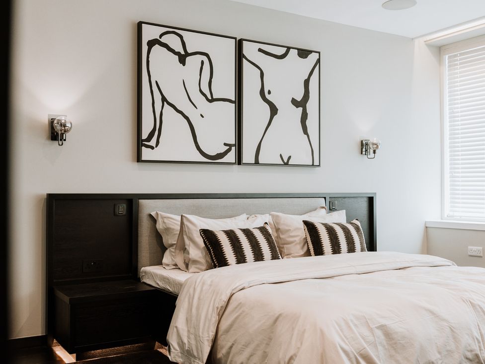 A bedroom with a bed and wall art at The Penthouse in Shrewsbury