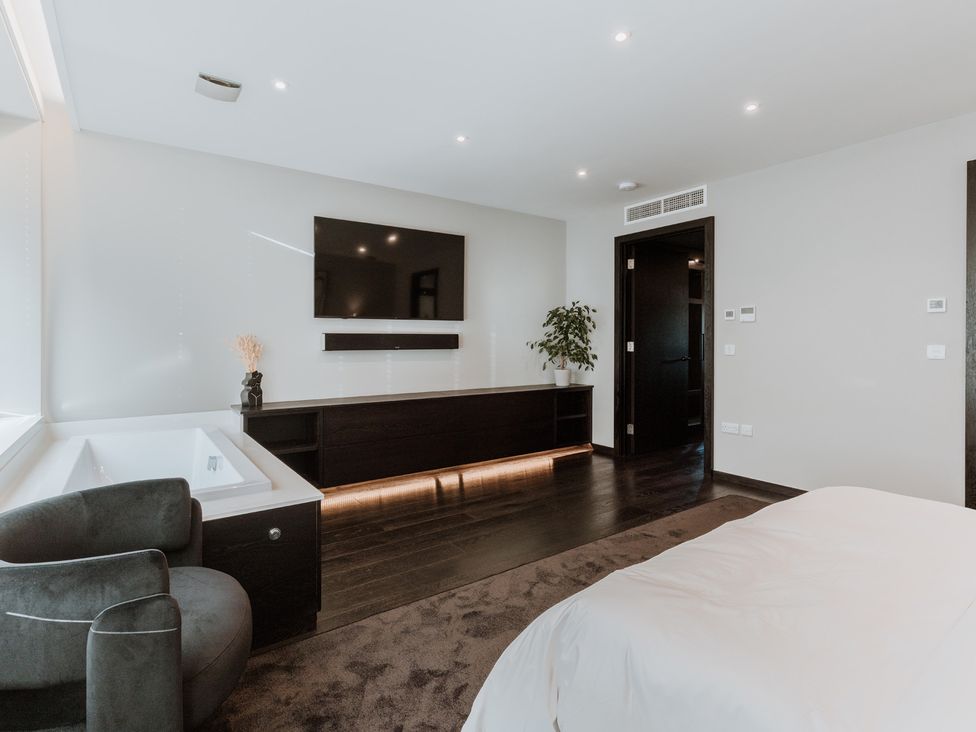 A bedroom with a television and bathtub at The Penthouse in Shrewsbury