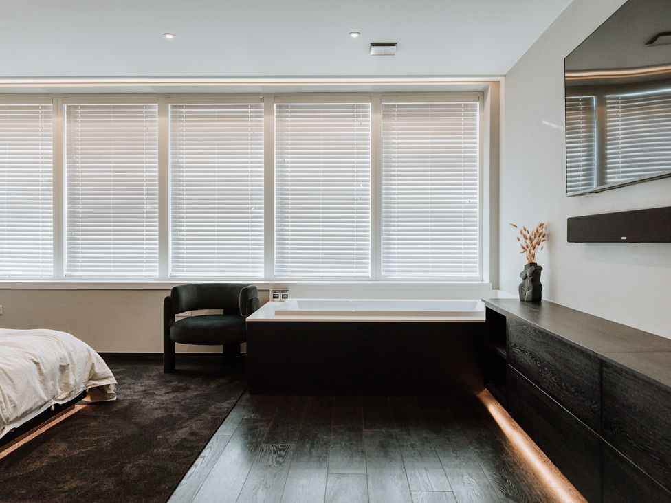 A bathroom with a bathtub and a television at The Penthouse in Shrewsbury