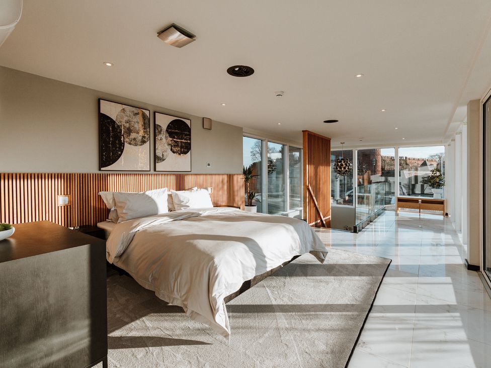 A bedroom with a bed and large windows at The Penthouse in Shrewsbury