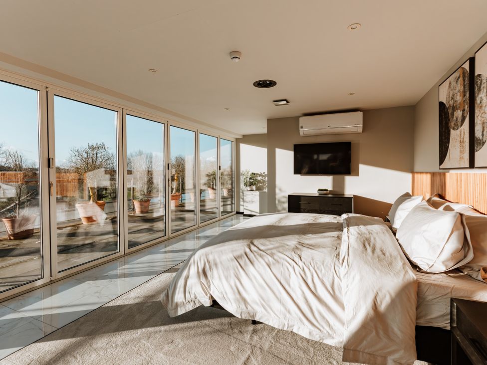 A bedroom with a bed and television at The Penthouse in Shrewsbury