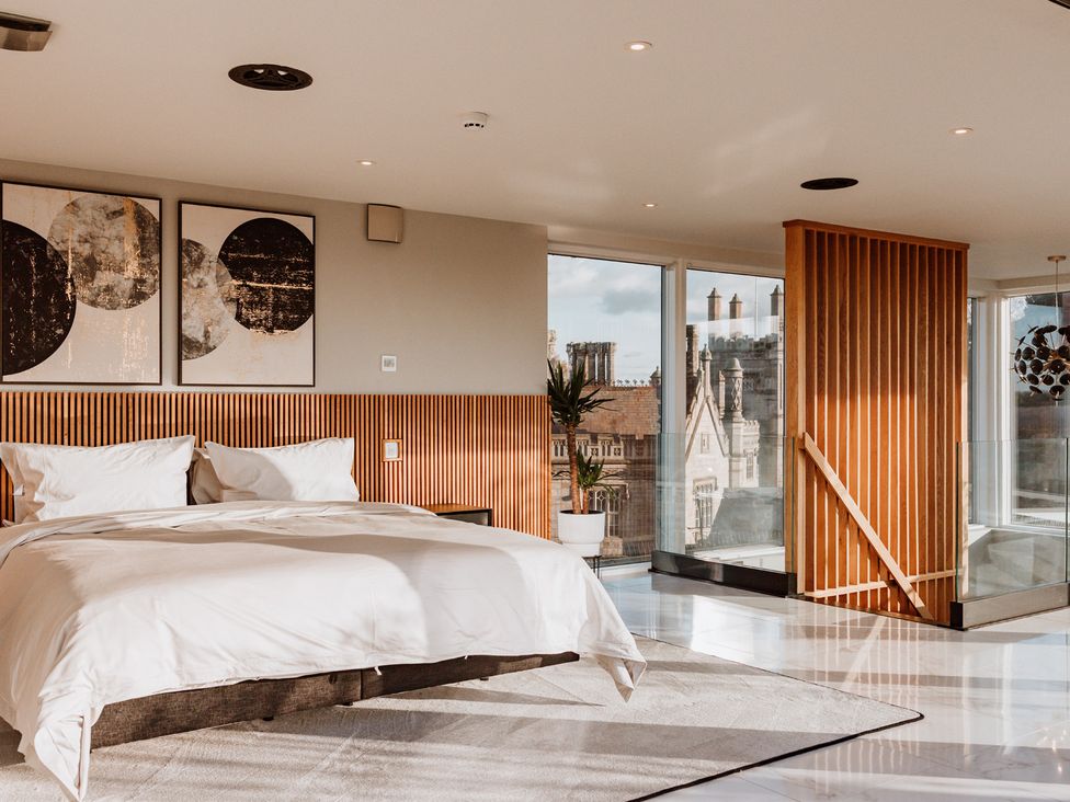 A bedroom with a bed and paintings at The Penthouse in Shrewsbury