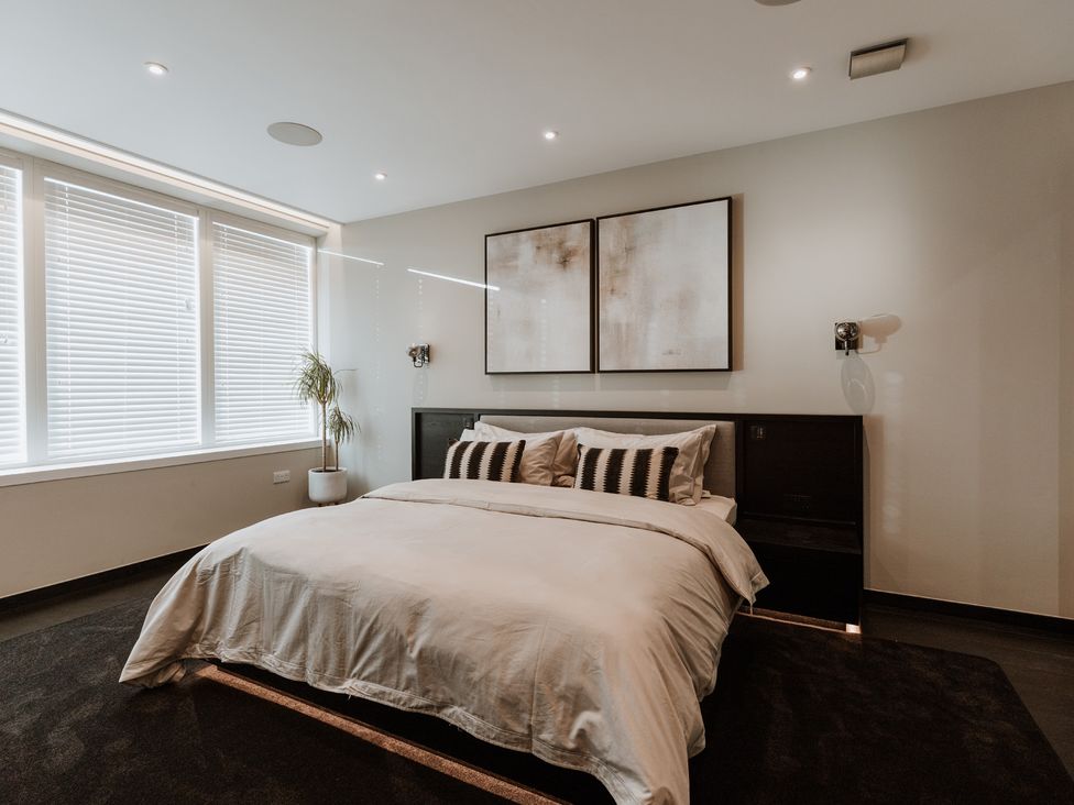 A bedroom with a bed and bedside lamps at The Penthouse in Shrewsbury
