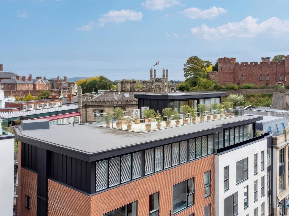 A rooftop terrace with planters and city view at The Penthouse in Shrewsbury