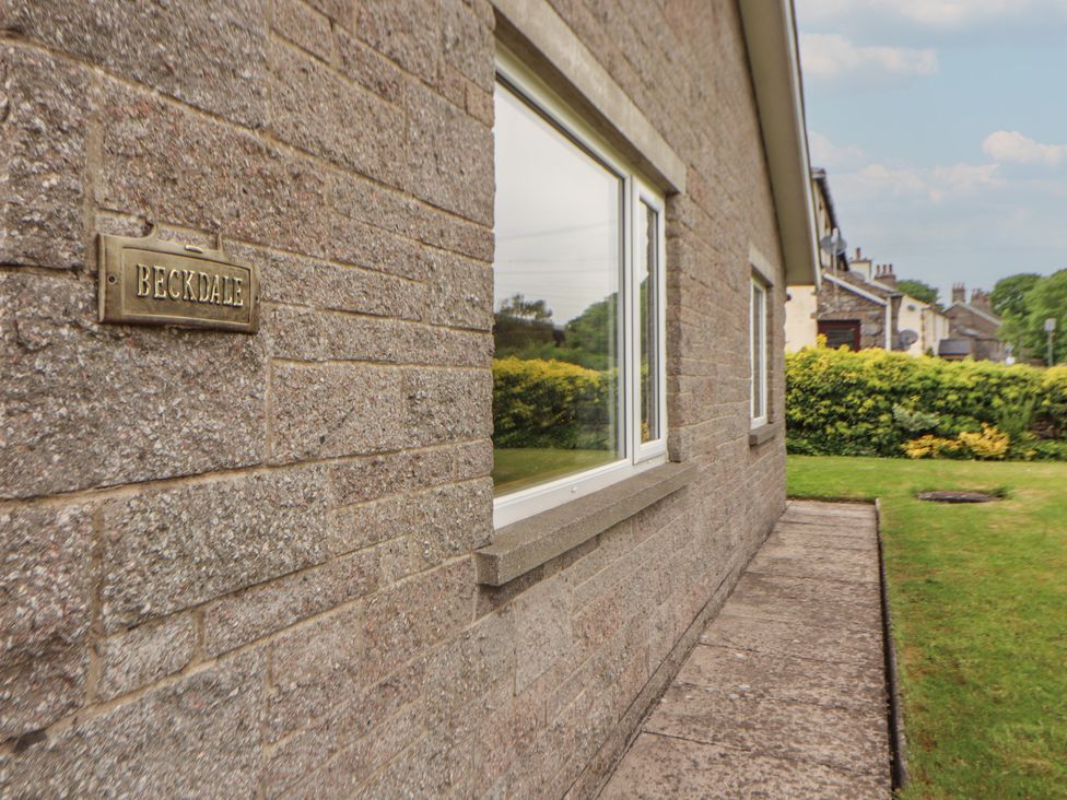 An exterior view of a house with a sign at Beckdale in Settle
