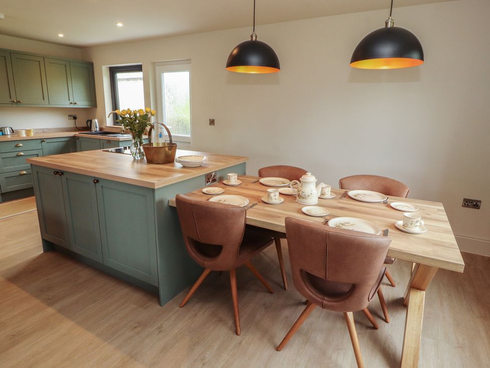 A kitchen with an island and dining table at Beckdale in Settle