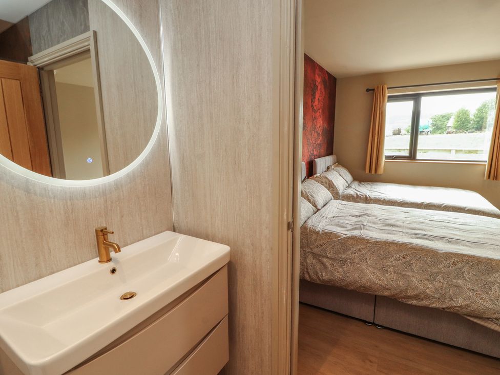 A bathroom sink with a mirror beside a bedroom at Beckdale in Settle