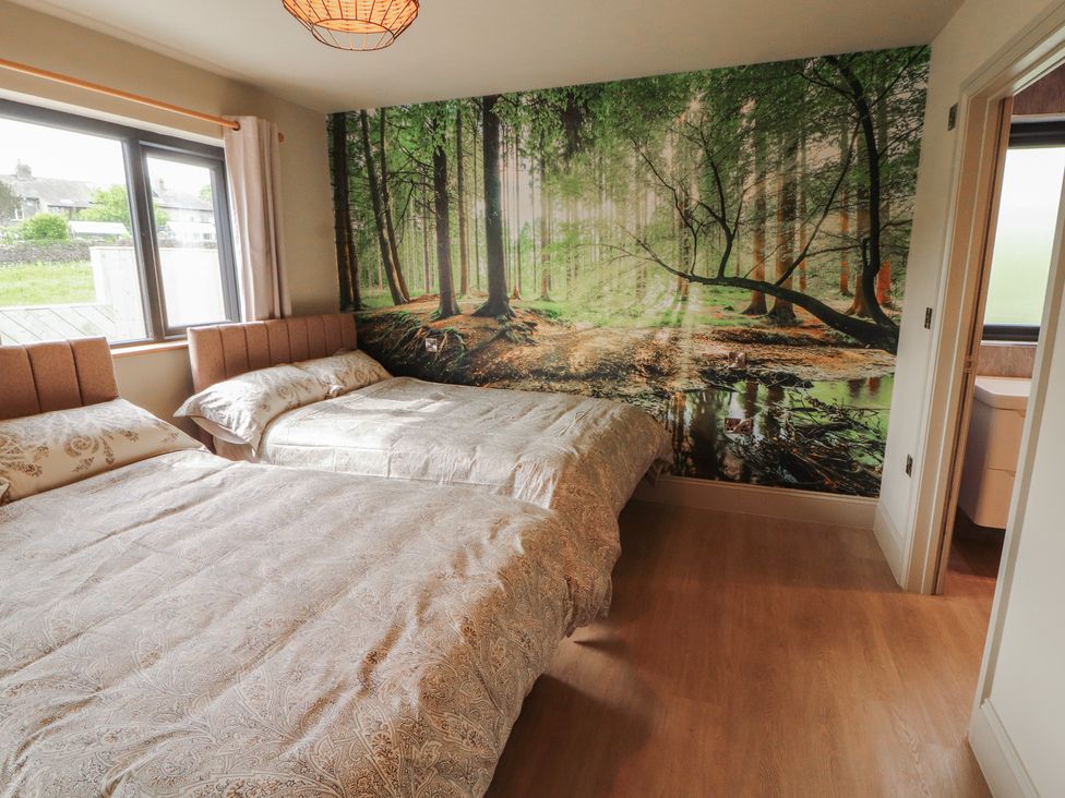 A bedroom with two beds and a forest wall mural at Beckdale in Settle