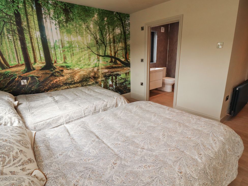 A bedroom with double beds and a wall mural at Beckdale in Settle