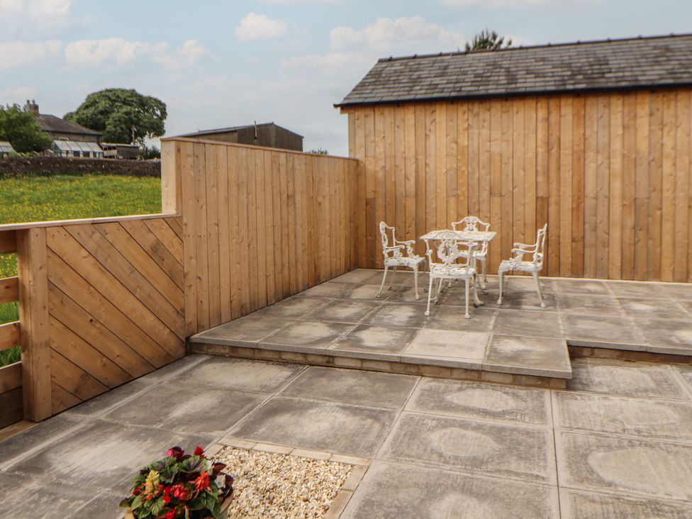 A garden with a patio set and wooden fence at Beckdale in Settle