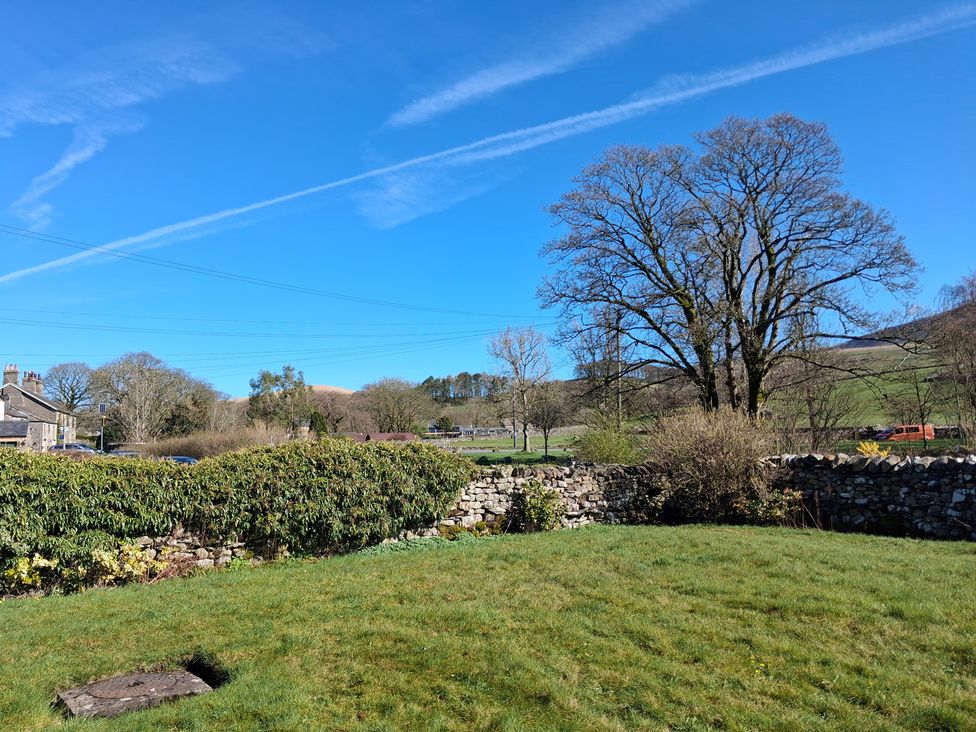 A garden with trees and a stone wall at Beckdale in Horton-in-Ribblesdale near Settle