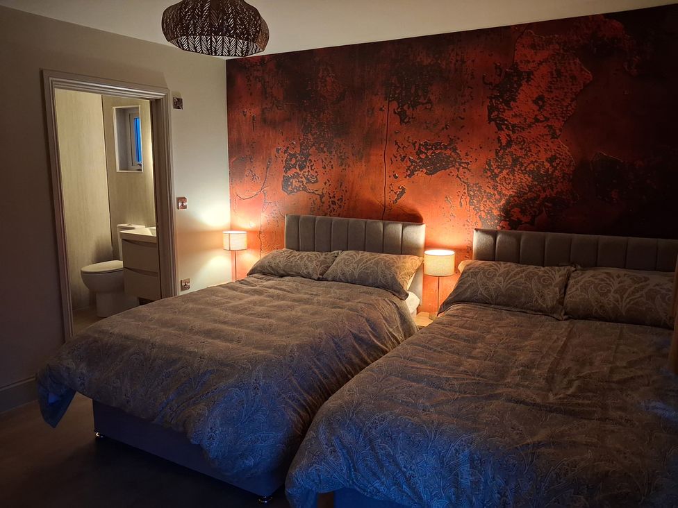 A bedroom with two beds and a bathroom visible at Beckdale Horton-in-Ribblesdale near Settle