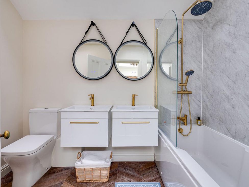 A bathroom with a double sink and two round mirrors in Luxury Georgian Townhouse / sleeps 10 / parking