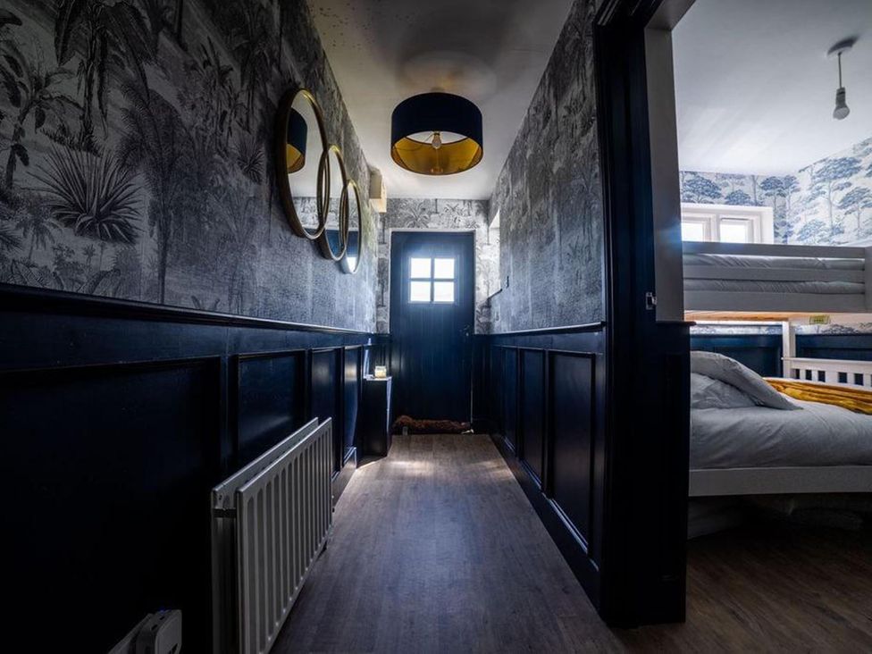 A hallway with mirrors and a door at Cottage, 3 Bed, Sleeps 7, Free Parking