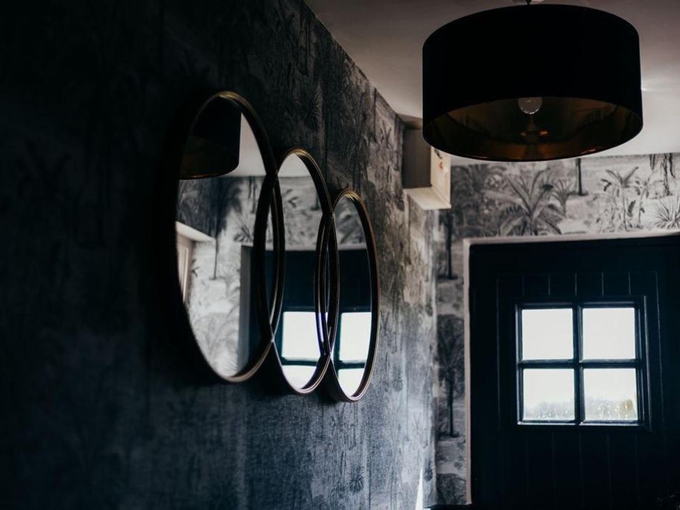 A hallway with three mirrors and a door at Cottage, 3 Bed, Sleeps 7, Free Parking