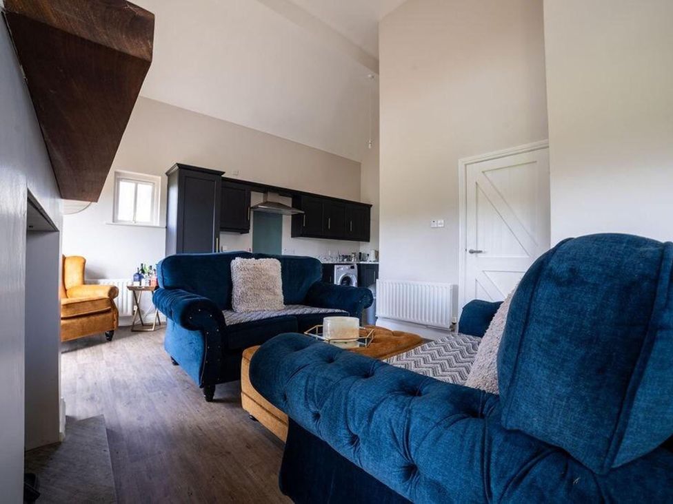 A living room with blue sofas and a coffee table at Cottage, 3 Bed, Sleeps 7, Free Parking