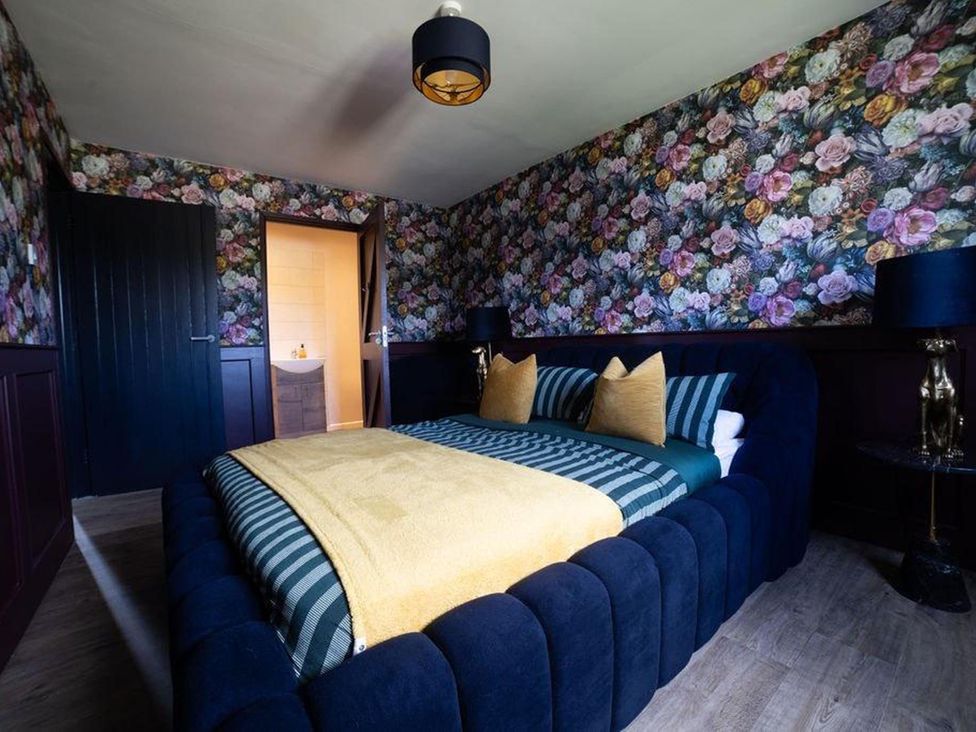 A bedroom with a bed and floral wallpaper at Cottage, 3 Bed, Sleeps 7, Free Parking