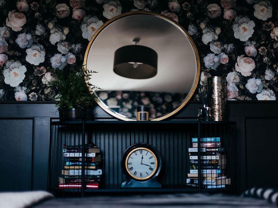 A shelf with a clock and books in a bedroom at Cottage, 3 Bed, Sleeps 7, Free Parking